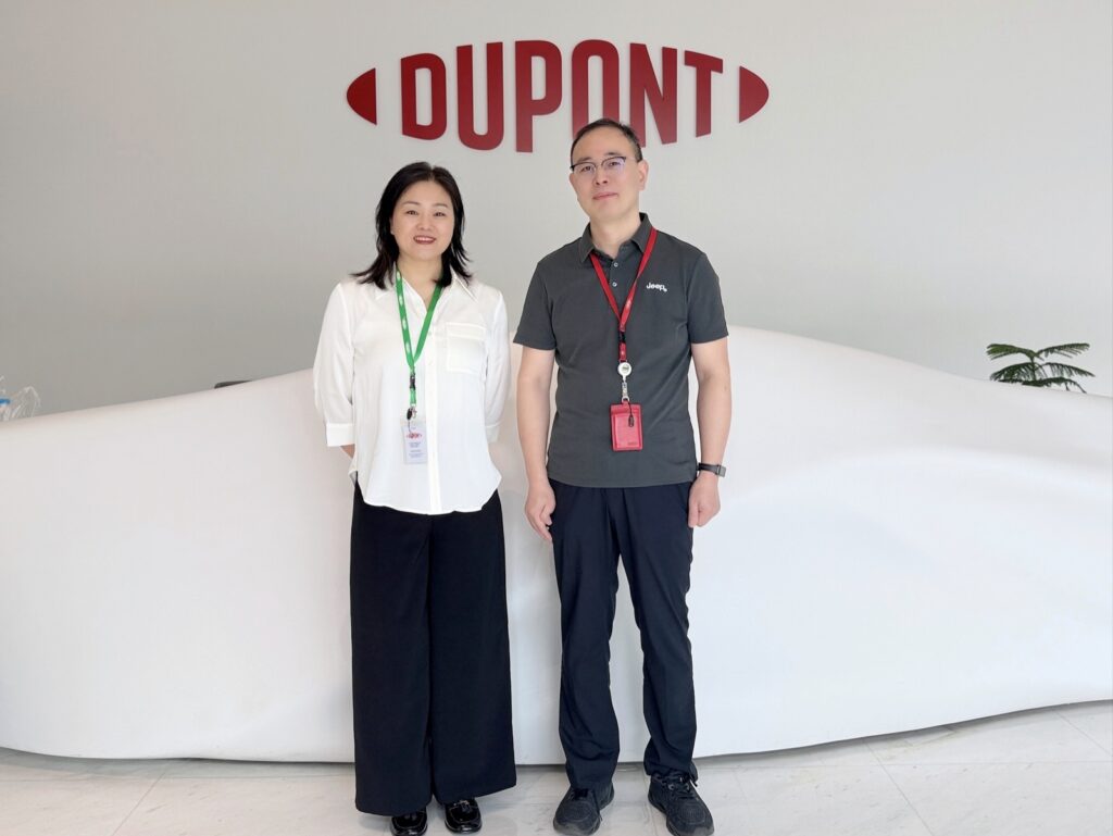 Two colleagues standing in front of the DuPont logo at the reception of DuPont Shanghai