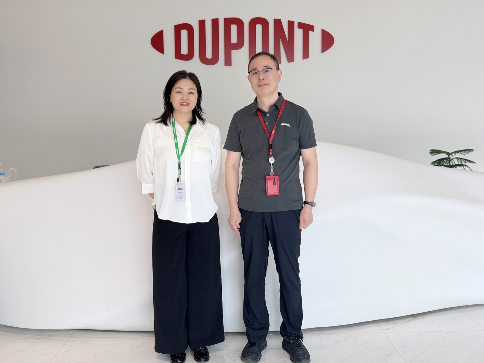 Two colleagues standing in front of the DuPont logo at the reception of DuPont Shanghai