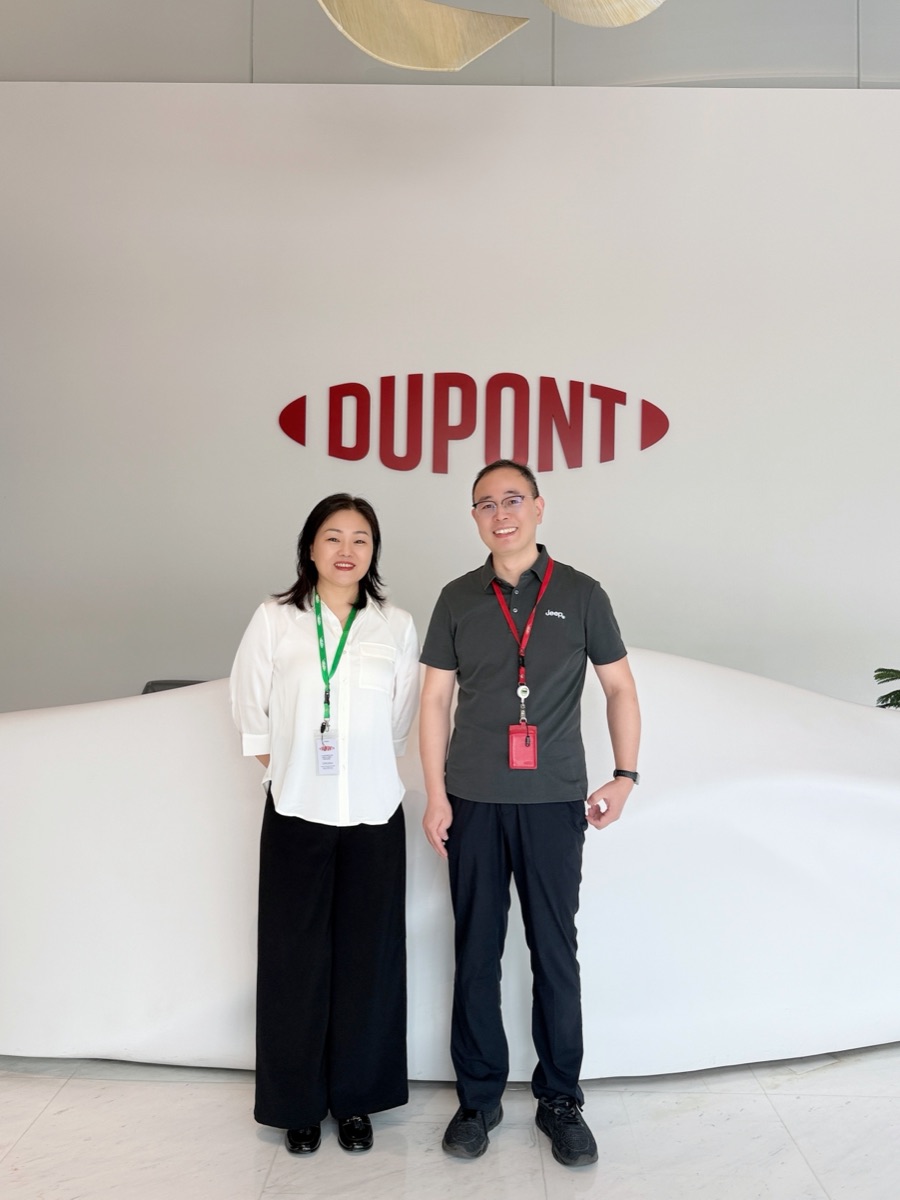 Two people standing in front of the DuPont logo on the reception wall at DuPont Shanghai