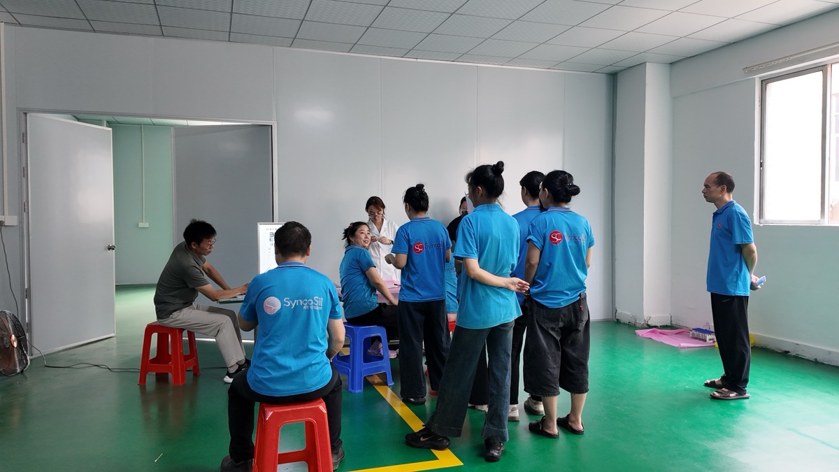 Employees in blue work uniforms at a consultation station during the 2026 annual employee health check-up